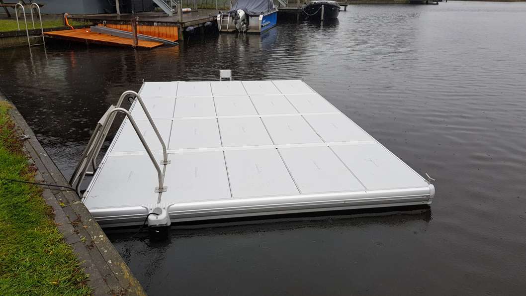 EasyFloat-flåte med motorfeste og sammenleggbar badestige langs kaien, en regnfull dag