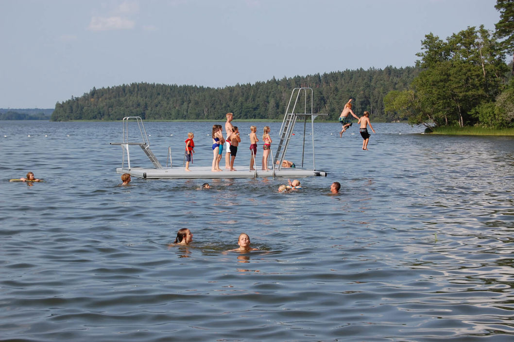 People waiting in line to jump from an EasyFloat swimming raft with diving towers in two heights
