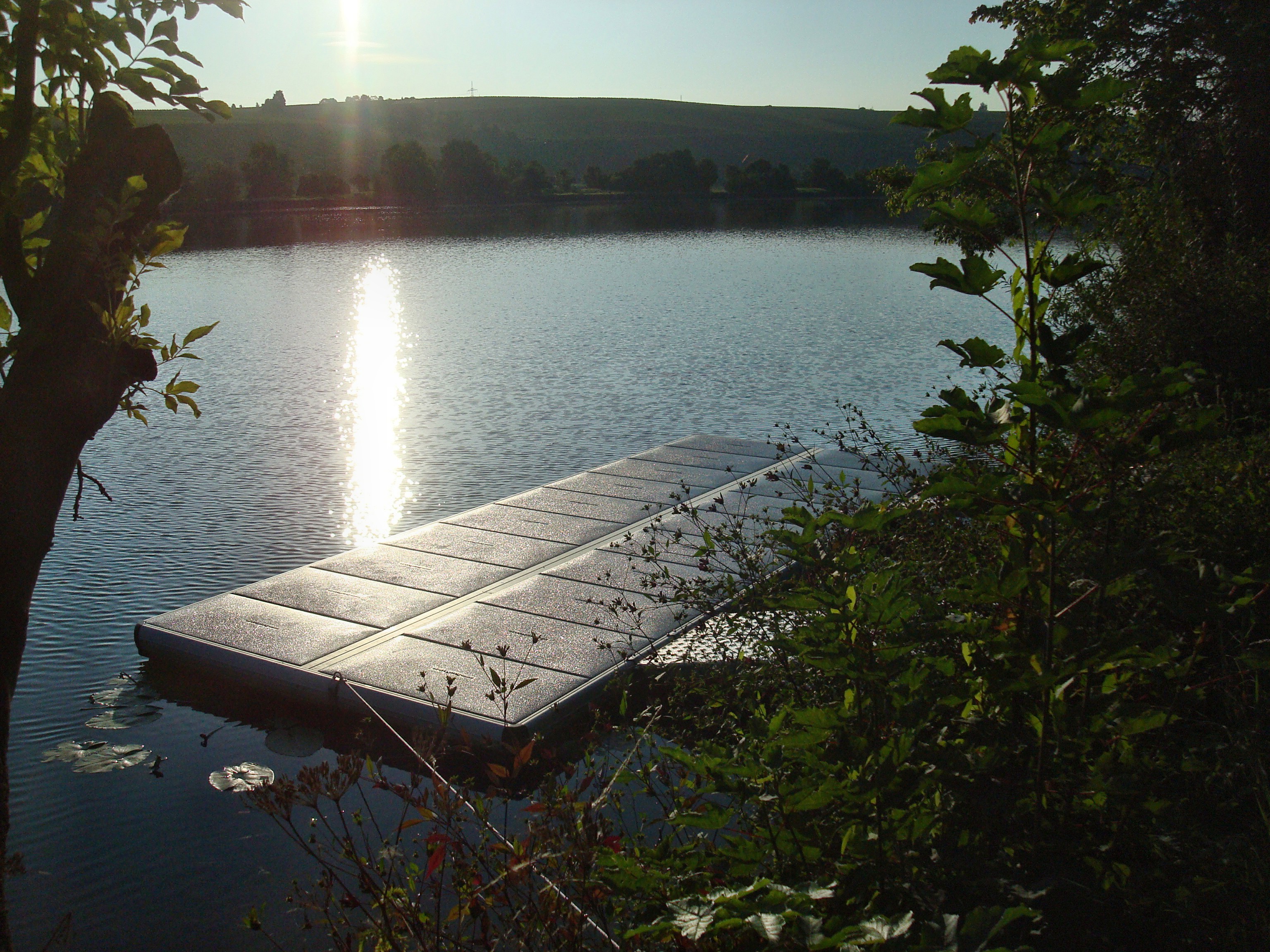 EasyFloat flytbrygga med landgång i Tyskland, med sol som glittrar på vattnet, möjligtvis för vattensport