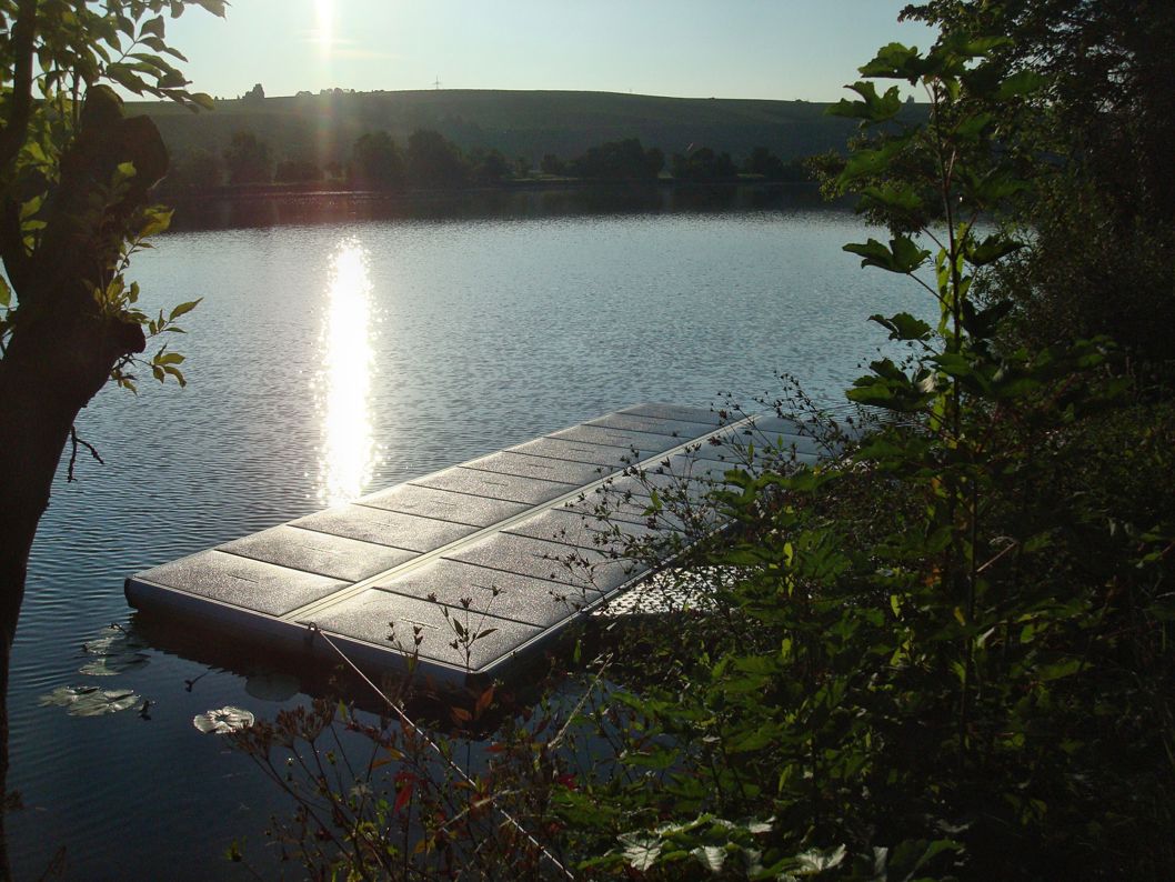 EasyFloat flytbrygga med landgång i Tyskland, med sol som glittrar på vattnet, möjligtvis för vattensport