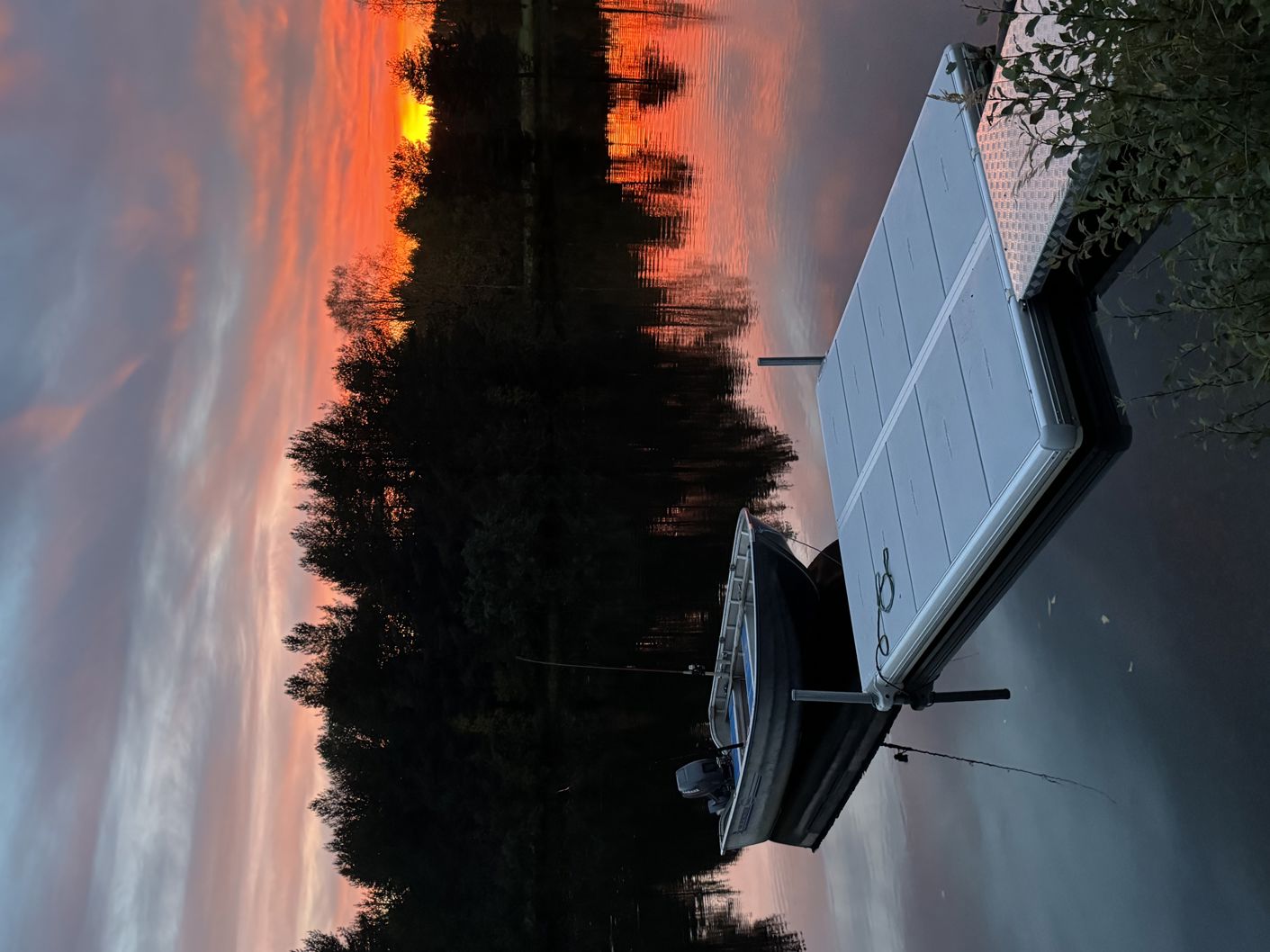 Petit ponton EasyFloat avec passerelle et bateau à moteur sur une eau calme au coucher du soleil