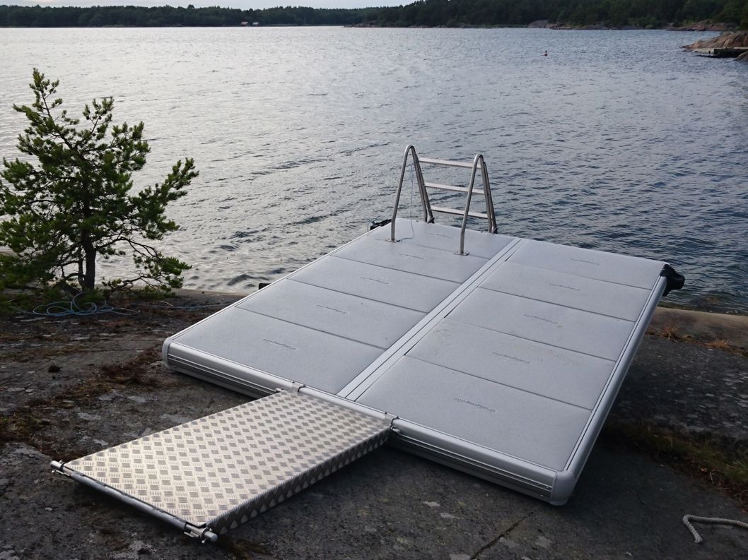 EasyFloat bathing float with gangway and ladder hauled ashore by the water, ready for use.