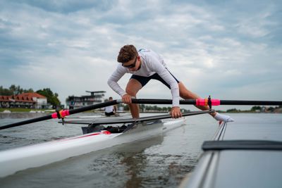 Roddare som tar ett steg ut från en EasyFloat roddbrygga för att gå i sin roddbåt i Szeged under sommaren