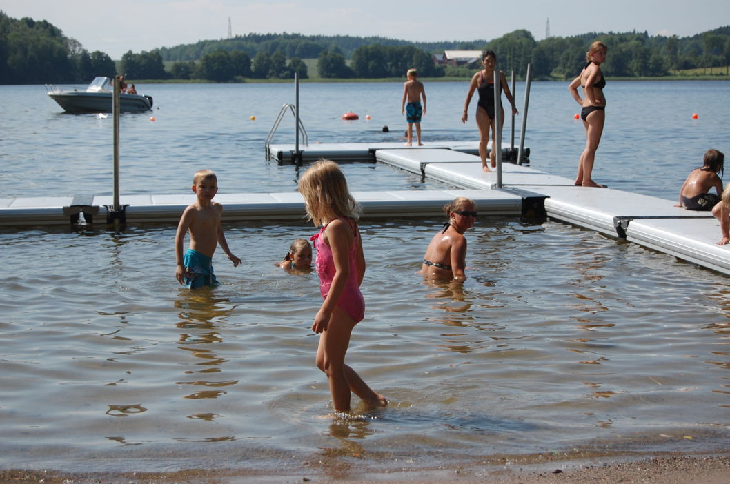 Children and adults swimming at a public EasyFloat floating dock at Stendalsbadet during summer