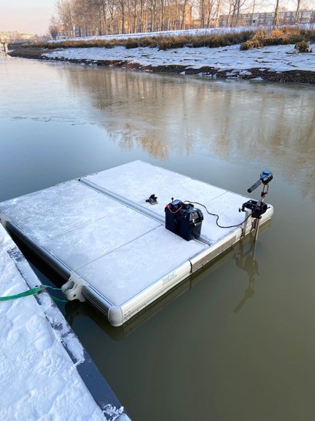 EasyFloat work platform covered with snow and ice, with a motor mounted for work on water during winter