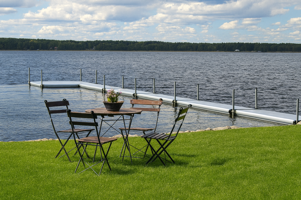 L-shaped EasyFloat floating dock at Vidöstern with lawn and café table